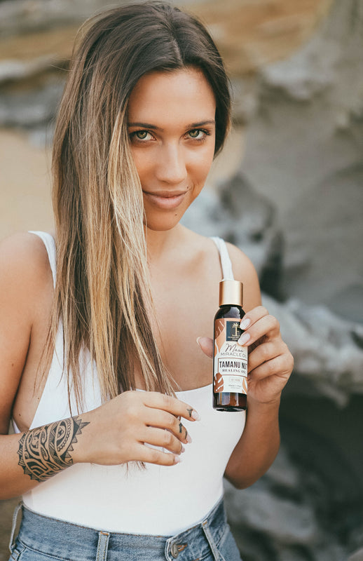 Girl on beach with Maui Miracle Tamanu Nut Healing Oil